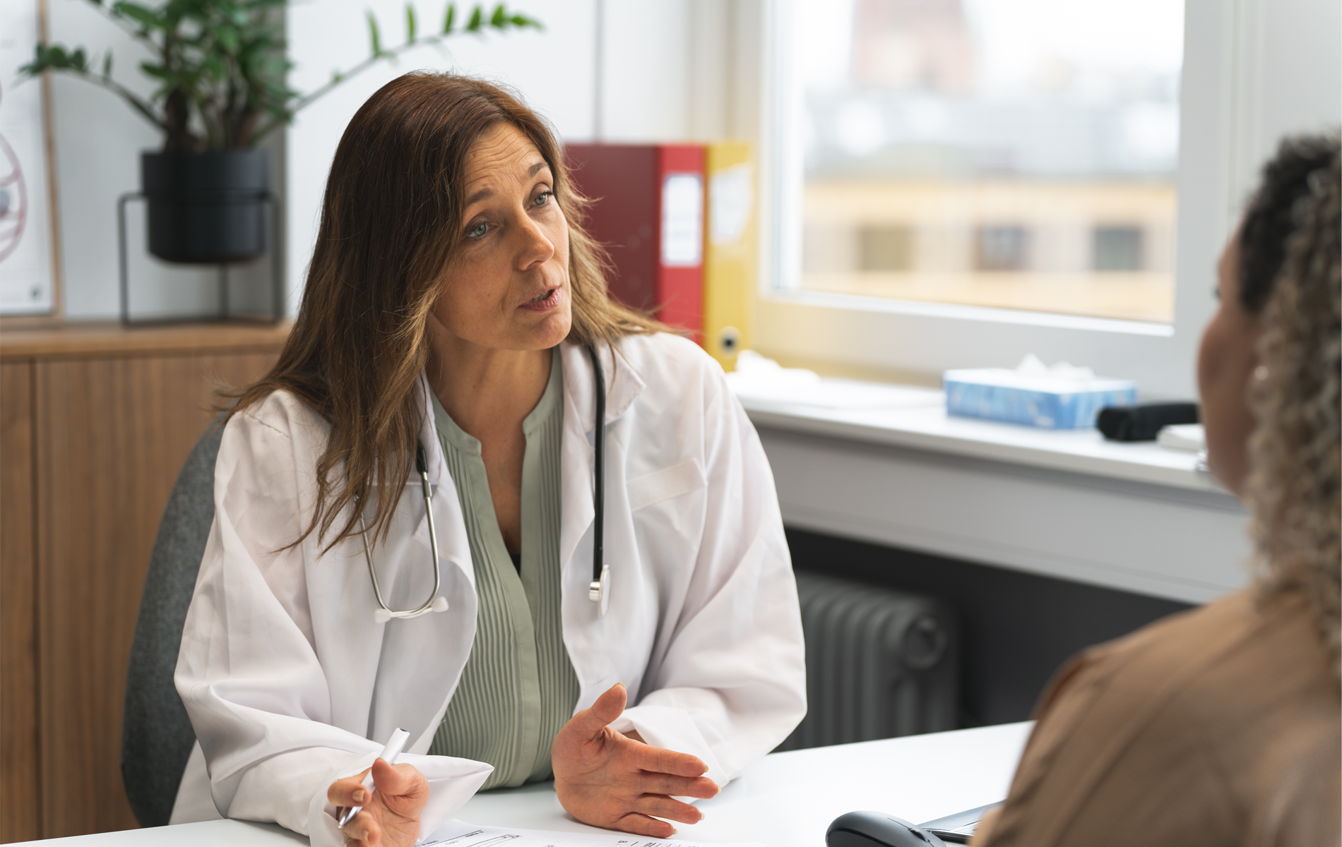 ผู้หญิงกําลังพูดคุยกับแพทย์